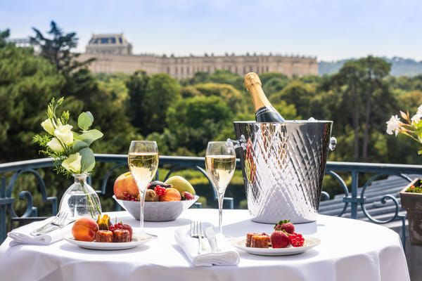 table gastronomique avec champagne devant le château de Versailles